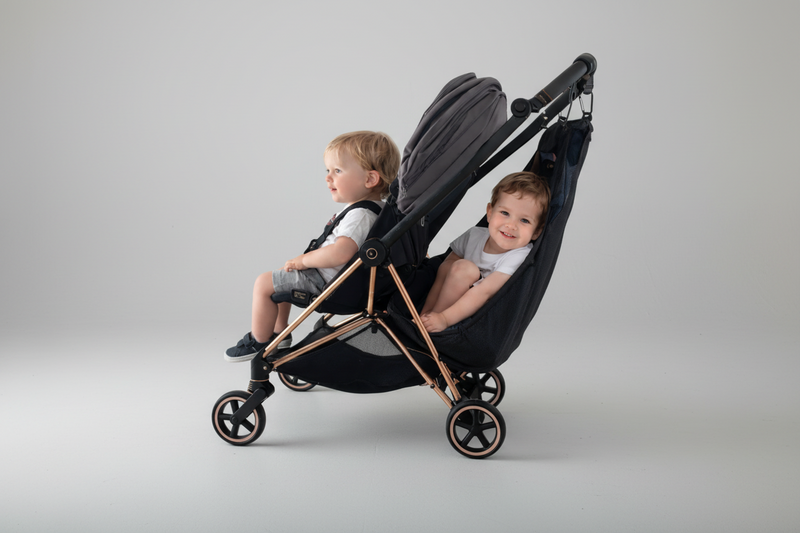 Two kids in a single stroller with the stroller sling hammock